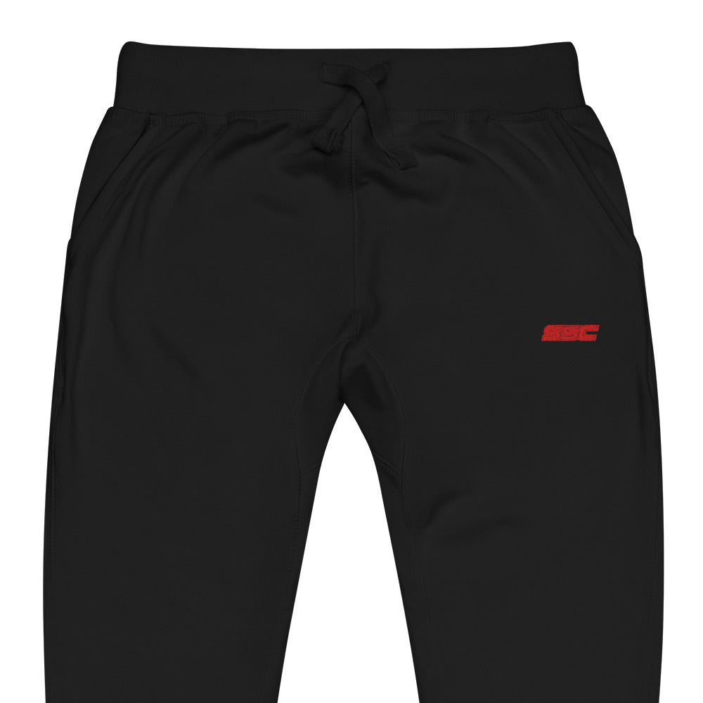Close-up of small red SSC embroidery at the upper left leg of black signature fleece joggers