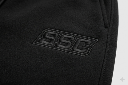 Black SSC CORE Black Tech Suit, close-up of chest embroidery and chevron panel.
