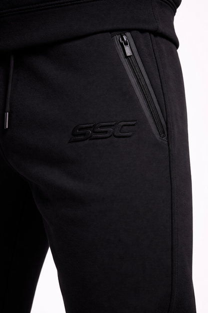 Black SSC CORE joggers, thigh embroidery and zipper pocket detail.